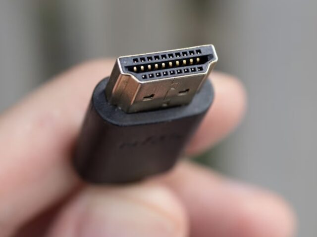 Close-up of a real HDMI plug held between finger and thumb